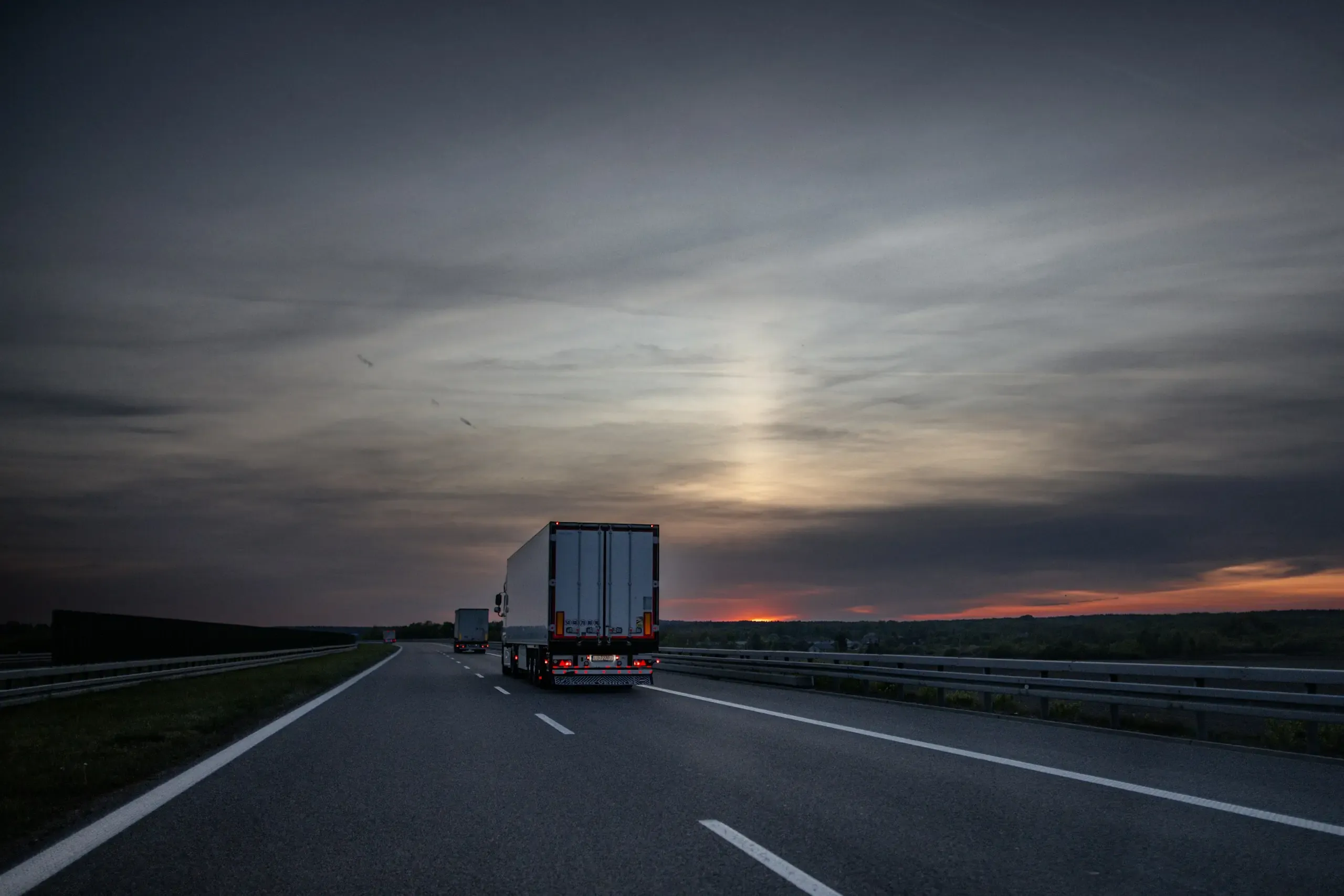 Camions de livraison sur l’autoroute au coucher du soleil